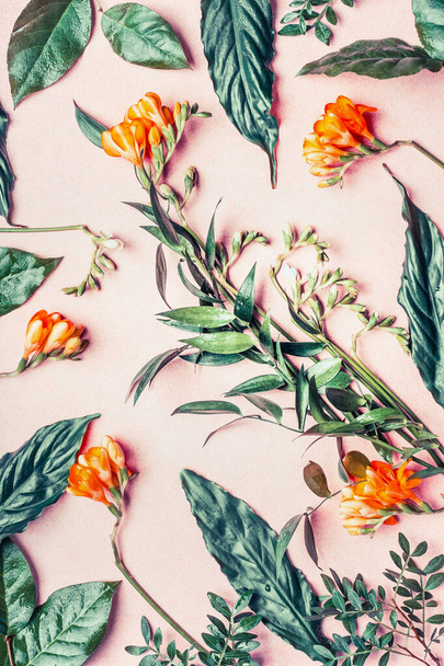 Creative flat lay made of tropical flowers and leaves on pastel pink background, top view - 写真・画像
