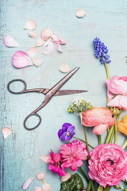 Summer flowers bunch making with various colorful flowers from garden and shears on blue vintage shabby chic background, top view, copy space - Foto, afbeelding