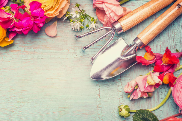 Summer flowers and gardening tools on vintage shabby chic background, top view, copy space - Fotó, kép