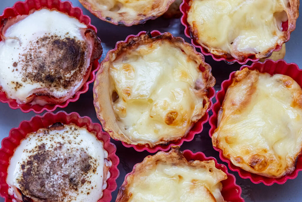 Delicious assorted flavors of freshly baked tarts in red cups in a top down or flat lay view in full frame - Photo, Image