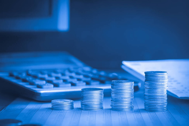 стопки грошової монети з калькулятором і фоном облікової книги з синім фільтром
 - Фото, зображення