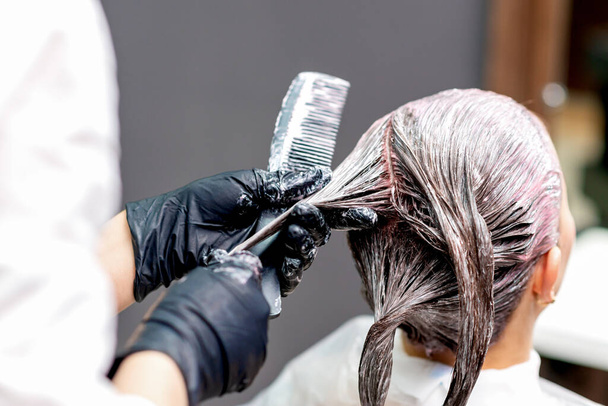 Rückansicht der Hände des Friseurs Färben der Haare der Frau, Nahaufnahme. - Foto, Bild