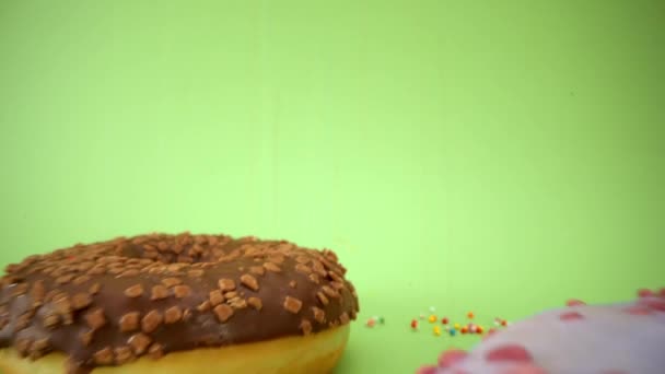 Laowa 24mm probe lens passing through beautiful colorful donut. Tasty donuts close up. Sweet dessert. Sprinkling. Green background. Inside of donut. 4K - Imágenes, Vídeo