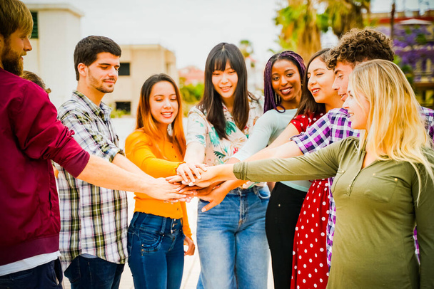Młodzi ludzie razem wzięci. Przyjaciele z stertą rąk pokazujących jedność i pracę zespołową. skupić się na rękach - Obraz - Zdjęcie, obraz