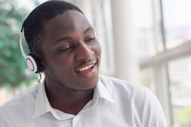 Afrikai fekete férfi zenét hallgat; portré nyugodt, gondtalan afrikai fekete férfi headset és zenelejátszó élvezi a dalt, és énekel együtt - Fotó, kép