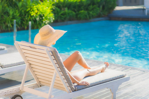 Retrato bonito jovem asiático mulher feliz sorriso relaxar ao redor piscina ao ar livre no hotel resort para lazer viagem férias - Foto, Imagem