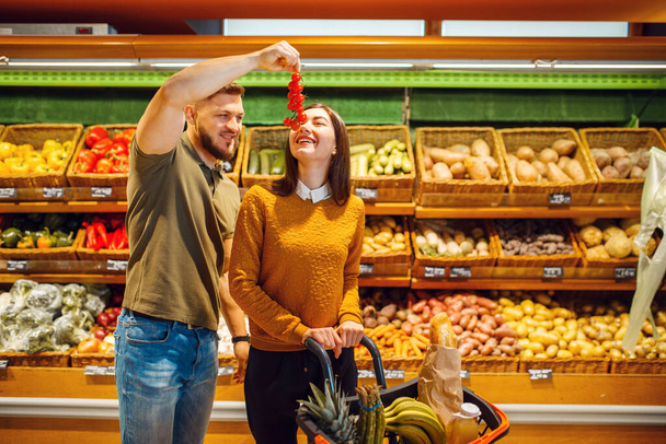 Coppia con cestino in supermercato insieme. Uomo e donna che acquistano frutta e verdura nel mercato, clienti che acquistano cibo
 - Foto, immagini