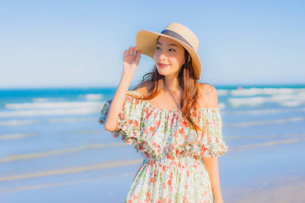 Retrato hermosa joven asiática mujer feliz sonrisa relajarse alrededor tropical playa mar océano en azul cielo para el ocio - Foto, Imagen