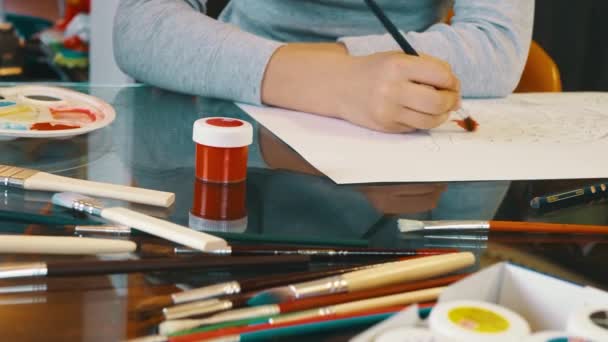 Primer plano de las manos del niño dibujo con pincel, paleta de colores, pinturas. Arte, educación y concepto de hobby
 - Imágenes, Vídeo
