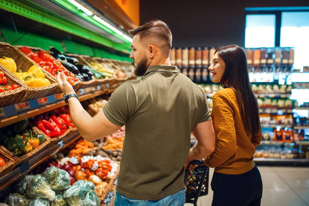 Para z koszykiem w spożywczym supermarkecie razem. Mężczyzna i kobieta kupujący owoce i warzywa na rynku, klienci kupujący żywność - Zdjęcie, obraz