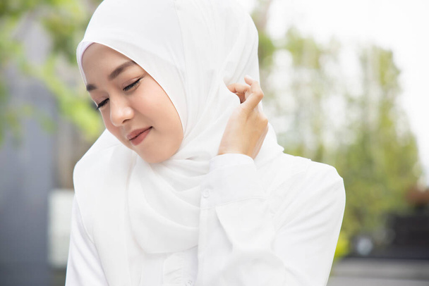 Μουσουλμάνα γυναίκα ξύσιμο του δέρματος του λαιμού της; ξηρό δέρμα, αλλεργική φλεγμονή του δέρματος, φροντίδα του σώματος, φλεγμονή μύκητα, δερματολογική νόσος, έκζεμα, εξάνθημα, έννοια φροντίδας του δέρματος; νεαρός ενήλικας ισλαμική γυναίκα μοντέλο - Φωτογραφία, εικόνα