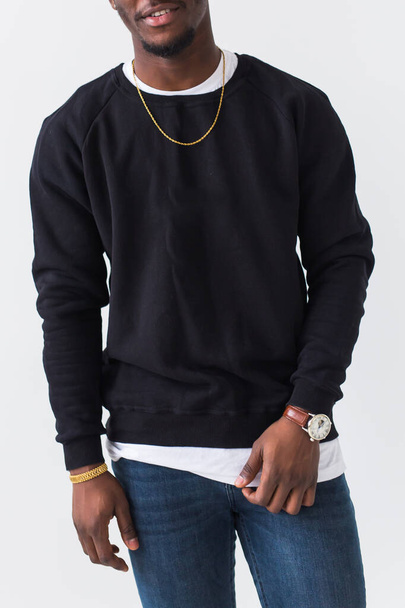 Youth street fashion concept - Close-up of confident sexy black man in stylish sweatshirt on white background. - Photo, Image