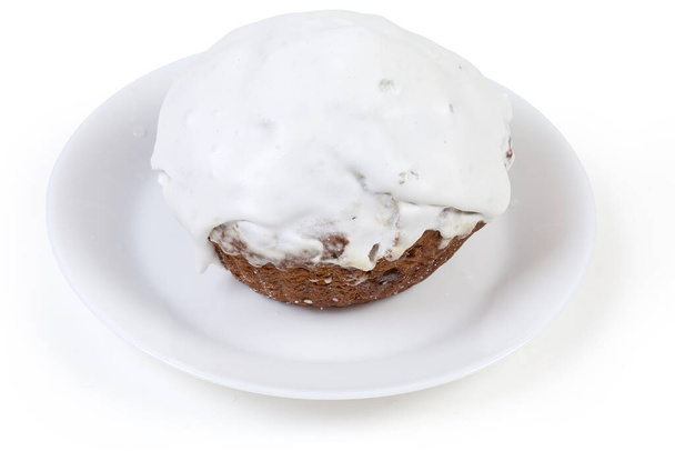 Big cupcake covered with whipped egg whites icing on the white dish on a white background - Photo, Image