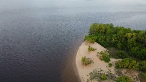 Aerial drone scene of beach at natural landscape at sunset. General panorama, flying along beach of sand and forest at river. A wild deserted island in the middle of a river - Imágenes, Vídeo