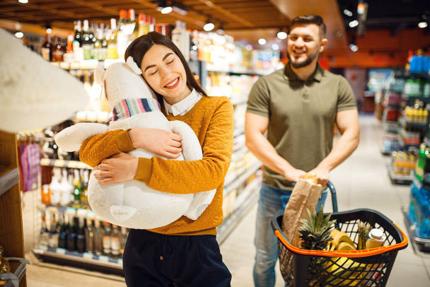 Coppia di famiglia al supermercato, consumismo. Uomo e donna con carrello acquisto di bevande e prodotti sul mercato, clienti shopping cibo e bevande
 - Foto, immagini