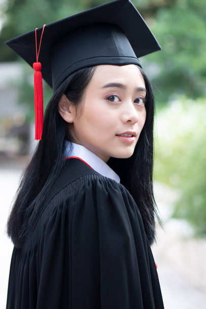 smart college student graduating looking back over shoulder; concept of successful education, happy commencement day, woman education opportunity, graduation, overseas study, education scholarships - Photo, Image