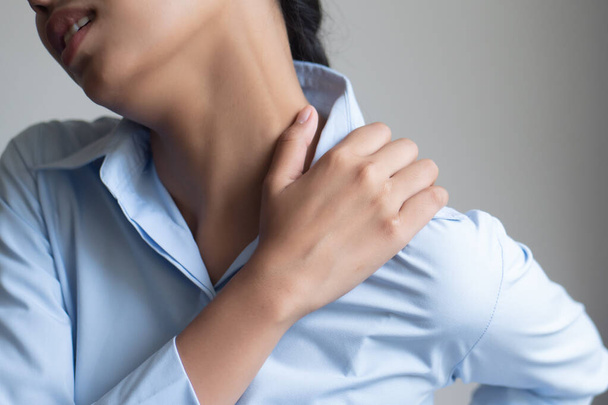 woman with shoulder or neck pain; portrait of asian woman suffering from shoulder or neck pain, stiffness, injury, chronic bone or muscle injury concept; asian young adult woman health care model - Foto, imagen