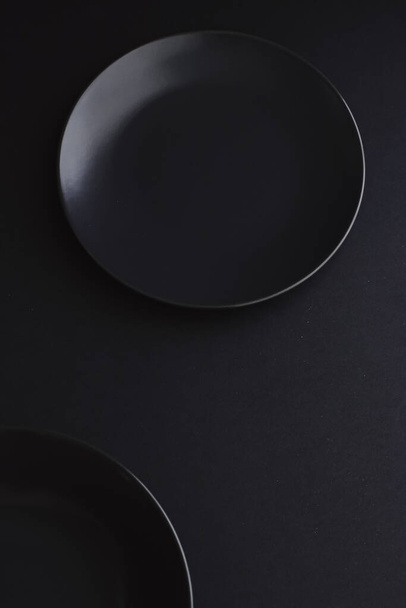 Пустые тарелки на черном фоне, посуда премиум класса для праздничного ужина, минималистичный дизайн и диета
 - Фото, изображение