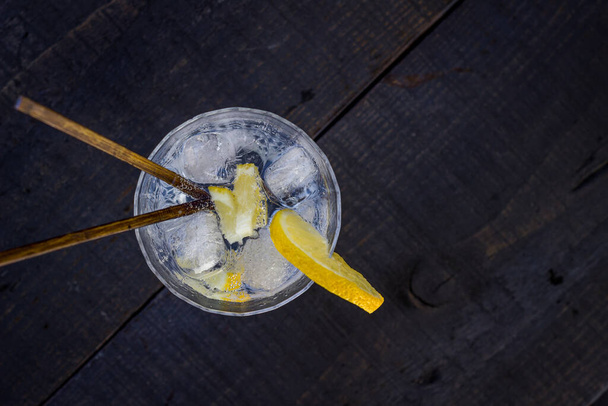Gin et verre tonique avec coin citron sur table noire. vue zénith
 - Photo, image