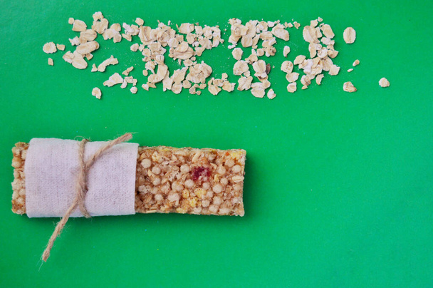 Cereal muesli bar y avena sobre un fondo verde
 - Foto, Imagen
