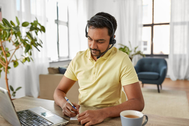 indian man with headset and laptop working at home - Foto, Bild