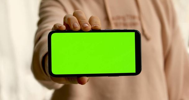 Mujer muestra smartphone con pantalla verde
 - Foto, Imagen
