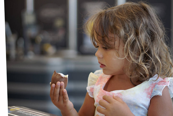4-letnia dziewczynka patrzy na czekoladowe jajko w supermarkecie w Grecji - Zdjęcie, obraz