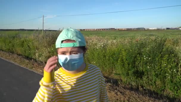 Dziewczyna z maską na twarzy na świeżym powietrzu - Materiał filmowy, wideo
