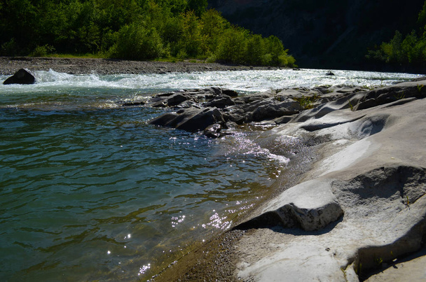 bergrivier tussen steile kliffen. blauw helder water van de rivier. - Foto, afbeelding