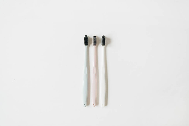 Oral care toothbrushes on white background. Flat lay, top view minimal dental hygiene concept - 写真・画像