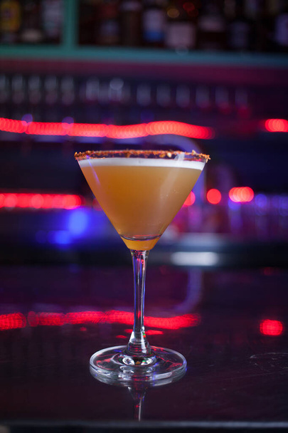Vertikální fotografie sklenice s koktejlem v baru s barevnými neonovými světly v noci - Fotografie, Obrázek