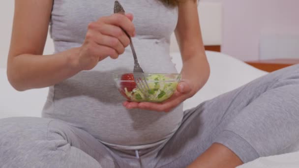Çatallı hamile bir kadın sebze salatası yer, iyi beslenir. Hamile bir kadın doğmamış çocuk için faydalı bir sebze salatası yer. Uygun beslenme kavramı. - Video, Çekim