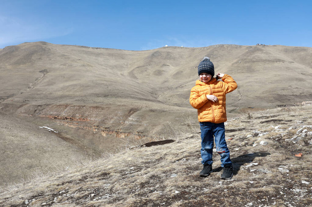 Boy posing on rocky ridge of Caucasus background, Kabardino-Balkaria, Russia - Foto, immagini