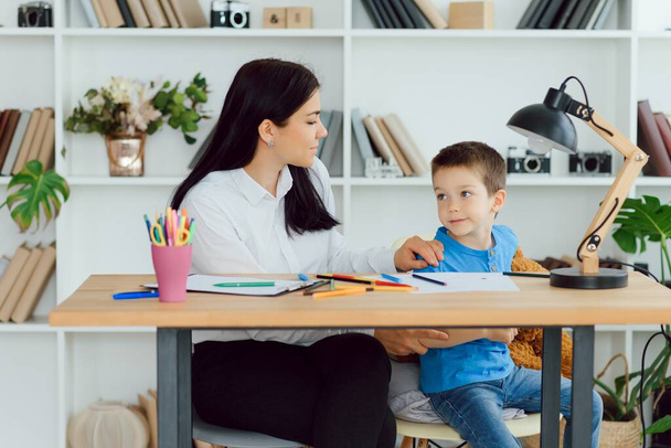 Young female psychologist working with little boy in office - Foto, afbeelding