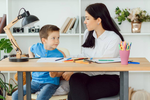 Jeune psychologue féminine travaillant avec un petit garçon au bureau
 - Photo, image