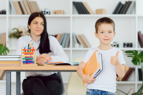 tutor deals with the preschooler with a laptop, a real home interior, the concept of childhood and learning - Фото, зображення