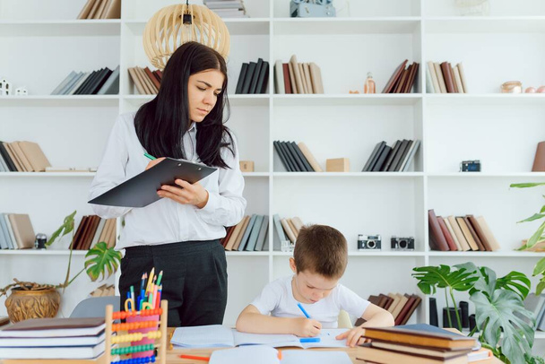 tutor deals with the preschooler with a laptop, a real home interior, the concept of childhood and learning - Valokuva, kuva