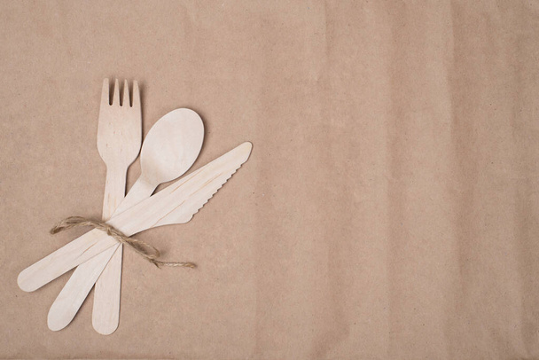 Using sustainable cutlery concept. Top above overhead view photo of a set of wooden cutlery placed to the left side isolated on craft paper background table - Fotó, kép