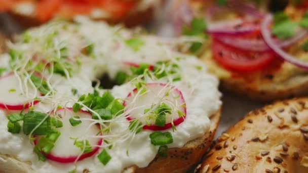 Assortiment van verschillende soorten toppings zelfgemaakte bagels sandwiches met sesam en maanzaad - Video