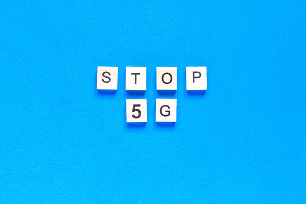 stop 5 g. 5 G. Five G's, written in wooden letters on a blue background. Flat layout. Wireless network. New technology. top view. - 写真・画像