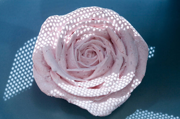 Belles roses décoratives marshmallow roses comestibles tourné à travers le filet, de belles ombres et des couleurs délicates, flou sélectif de l'arrière-plan
. - Photo, image