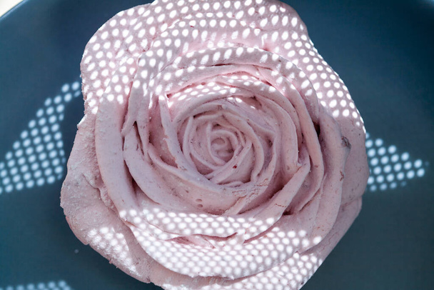 Hermosas rosas de malvavisco decorativo rosa comestible tiro a través de la red, hermosas sombras y colores delicados, desenfoque selectivo del fondo
. - Foto, Imagen