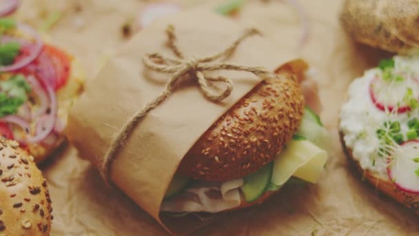 Bagels con jamón, queso crema, hummus, rábano envuelto en papel de hornear marrón listo para llevar
 - Metraje, vídeo