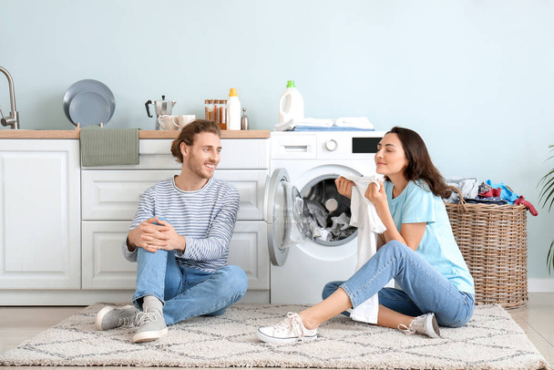 feliz jovem casal fazendo lavanderia em casa - Foto, Imagem