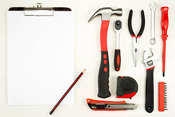 large set of construction tools with a sheet of white paper with a pencil on a white background, top view. - 写真・画像