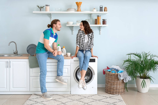 幸せな若いカップル行う洗濯に家で - 写真・画像