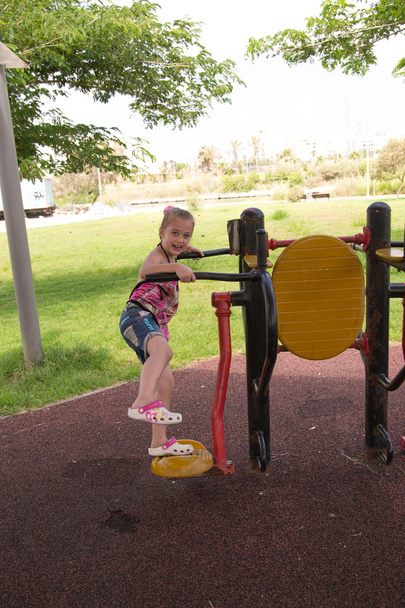 kislány a utcai edzőtermi gépek - Fotó, kép