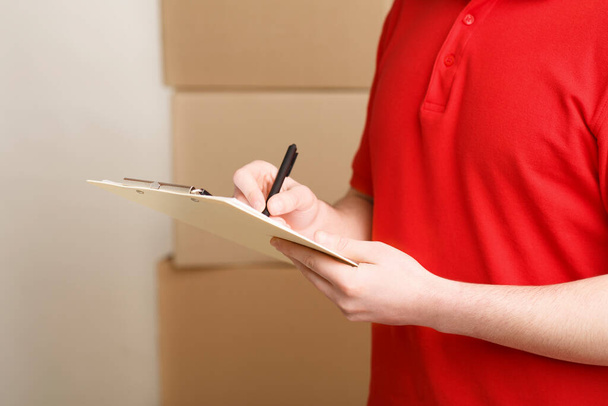 Post storage. Courier records order data for delivery of parcel - Photo, Image