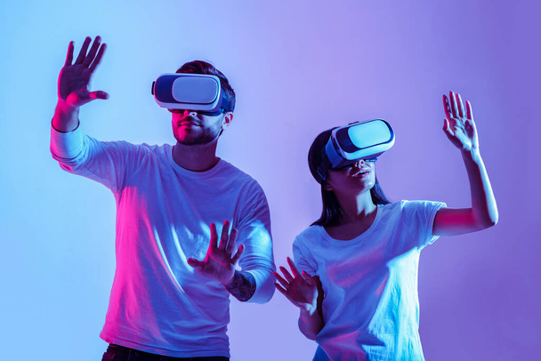 Digital world. Couple in virtual glasses make hands movements - Photo, image