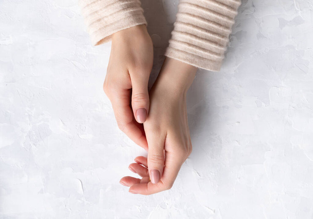 Gyönyörű fiatal nők kezek egészséges bőr és meztelen manikűr szürke háttér. Szépségszalon mock up sablon - Fotó, kép